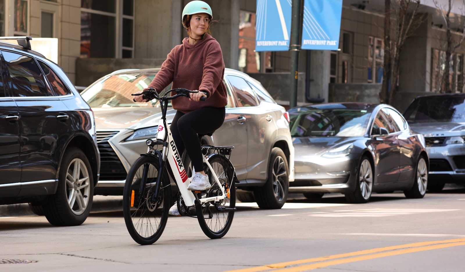 man in brown jacket riding on bicycle during daytime